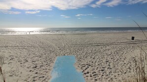 En strand med en blå matta i förgrunden, en sandstrand och havet i bakgrunden.