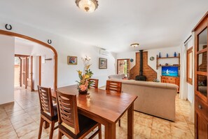 A spacious living area with a dining table, sofas, and a television. - 3 bedroom villa with gated pool in Pollensa, Tonia (Pollensa / Pollença)