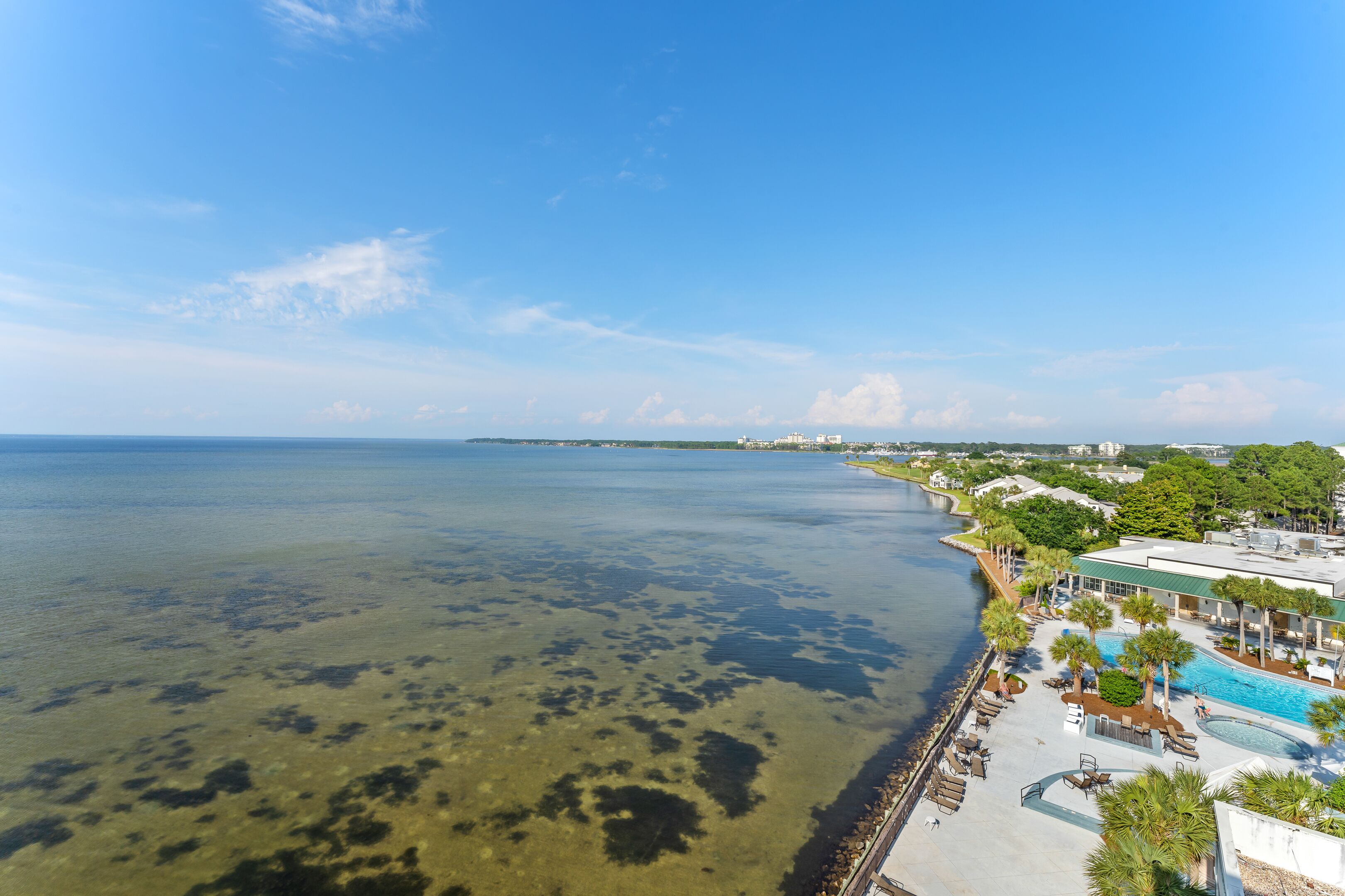 Un hotel frente al mar con piscina, playa y vistas al océano.