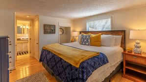 A bedroom with a bed, bedside table, lamp, and a window with blinds. - Sky Laurel Cottage - 3 bed 2 bath  home, 1 mile Walk to Blowing Rock, pet friendly (Blowing Rock)