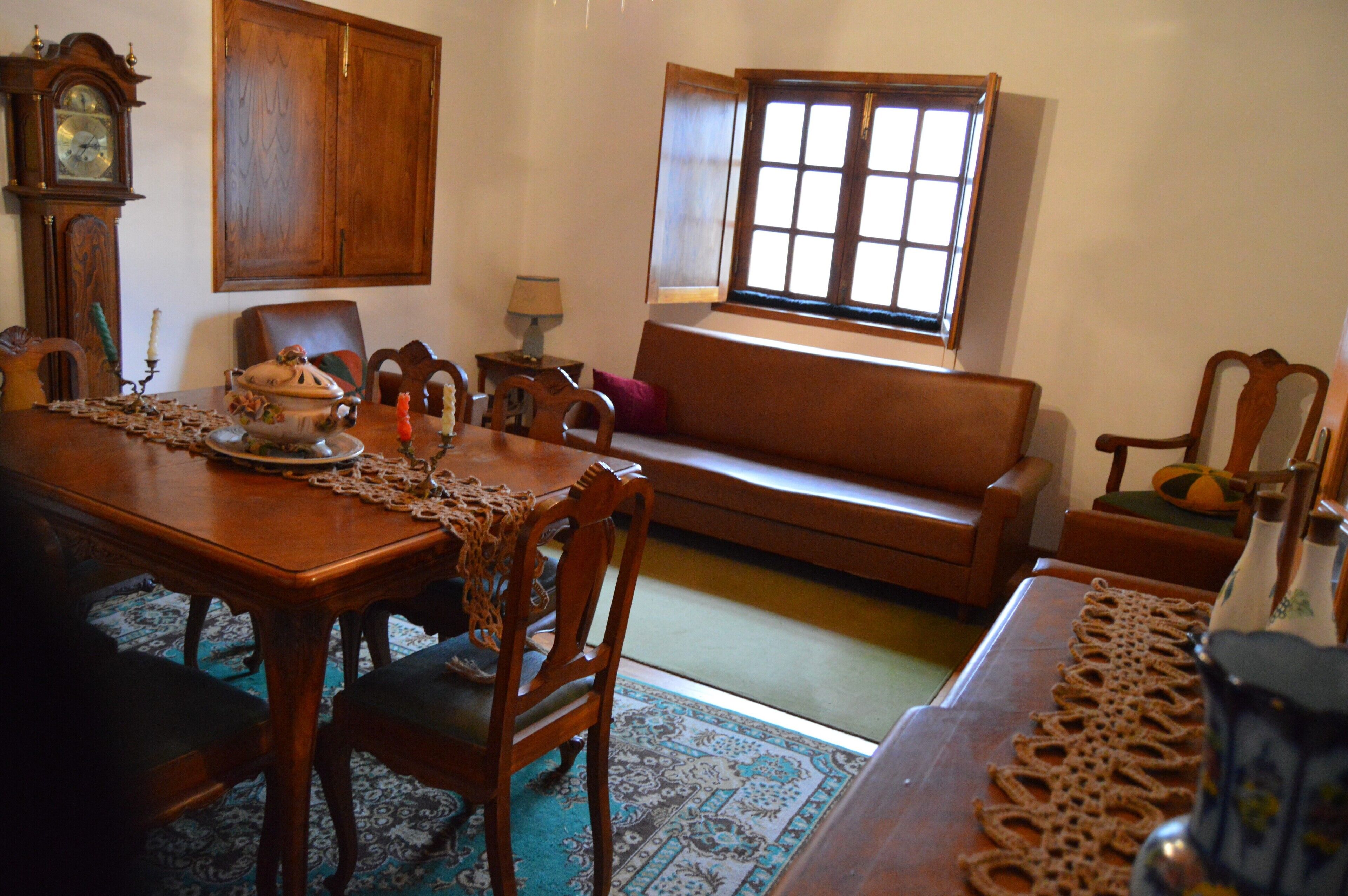 Un salon traditionnel avec une table à manger en bois, des chaises, un canapé et une fenêtre donnant sur un beau paysage.