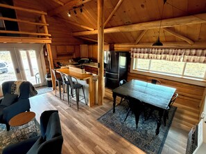 Een houten interieur met een eethoek, keuken en zithoek.