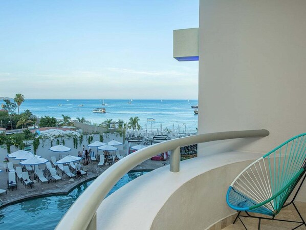 Enjoy the serene ocean views from this balcony overlooking the pool and sea.