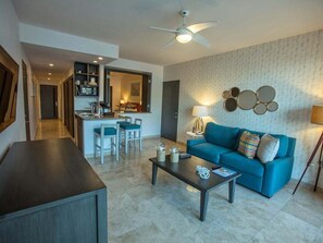 Relax in this stylish living space with a sofa, coffee table, and kitchen area.