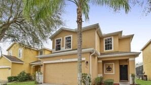 A two-story house with a garage, a front porch, and a landscaped yard. - Blue Jay Villa - Vacation Home Near Disney (Davenport)