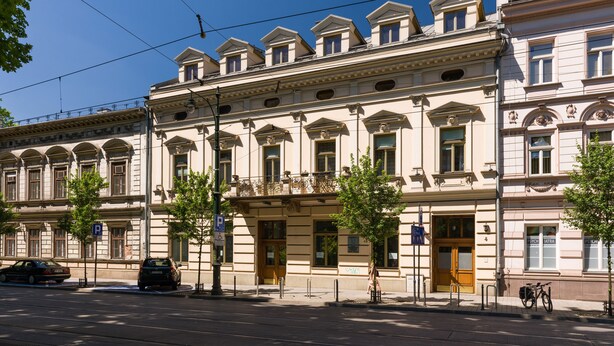 A row of classical buildings with symmetrical facades, large windows, and a central entrance. - KrakowRentals - Vanilla 7 Apartment (Kraków)