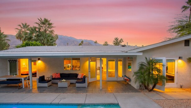 A modern house with a pool, outdoor seating, and a view of mountains at sunset. - Stylish PS Home w/heated pool/spa & mountain views (Palm Springs)