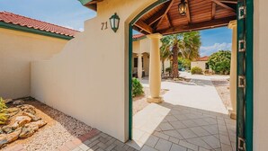 A building entrance with a tiled patio, a palm tree, and a clear sky. - 3Br W/ensuite Ba Near Beaches Private Pool&Jacuzzi (Noord)