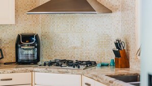 A kitchen with a gas stove, a coffee maker, and a knife block. - 3Br W/ensuite Ba Near Beaches Private Pool&Jacuzzi (Noord)