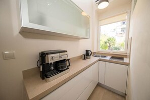 ثلاجة، موقد طهي مسطح، غسالة أطباق، ماكينة لصنع القهوة/الشاي