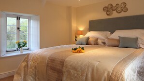 Ein Schlafzimmer mit einem großen Bett, einem Fenster mit Blumen und einem Wanddekor.