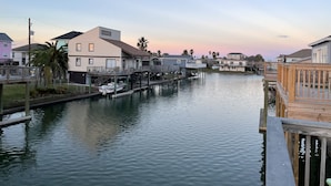 A canal with houses on stilts, wooden walkways, and a calm water surface. - Jamaica Beach Waterfront Home! w/ Paddleboards, Kayak, Pedal Boat, Fishing Gears (Jamaica Beach)