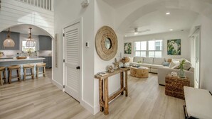 A spacious living area with a sofa, coffee table, and a console table with decorative items. - 4969 Estero Modern Pool Home across from Beach (Fort Myers Beach)