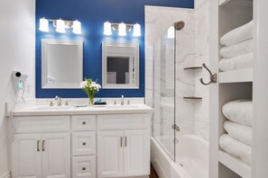 A modern bathroom with a double vanity, a large mirror, a shower enclosure, and a towel rack. - Home near Superdome and 10 minute drive to French Quarter. (New Orleans)