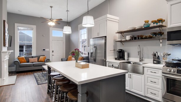 A modern kitchen with a central island, bar stools, a refrigerator, a stove, and a coffee maker. - Home near Superdome and 10 minute drive to French Quarter. (New Orleans)