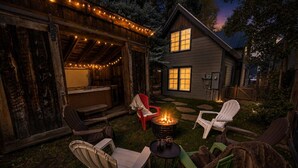 An outdoor seating area with chairs, a fire pit, and string lights. - Historic Elk Ave 3 Master Suites + Hot Tub - Walk Everywhere (Crested Butte)