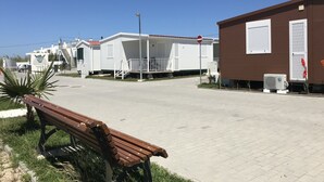 Una fila de casas móviles con un banco al frente.