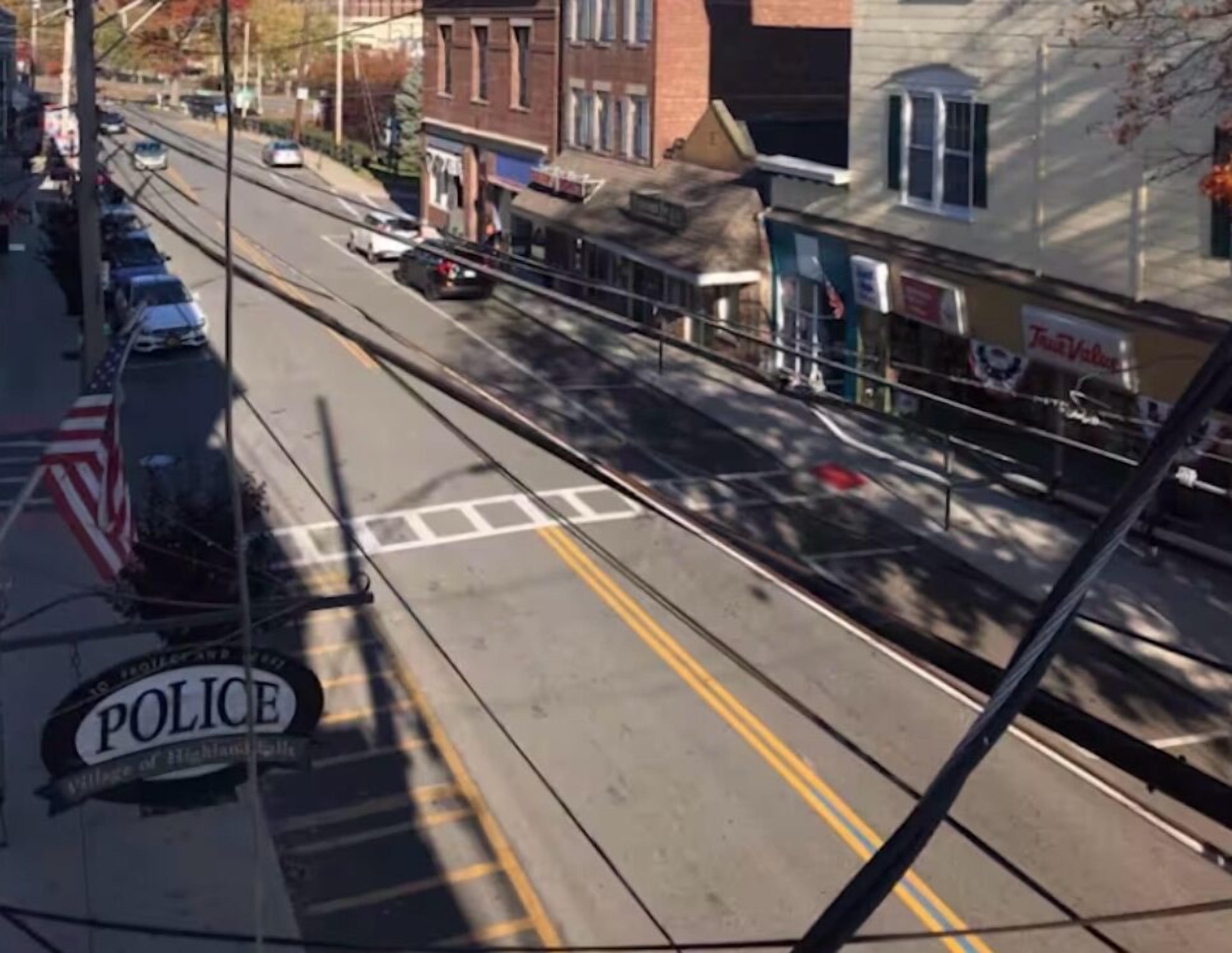 A street view with a police sign, parked cars, and buildings.