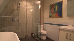 Un bagno moderno con doccia vetrata, un water bianco e una vasca da bagno.