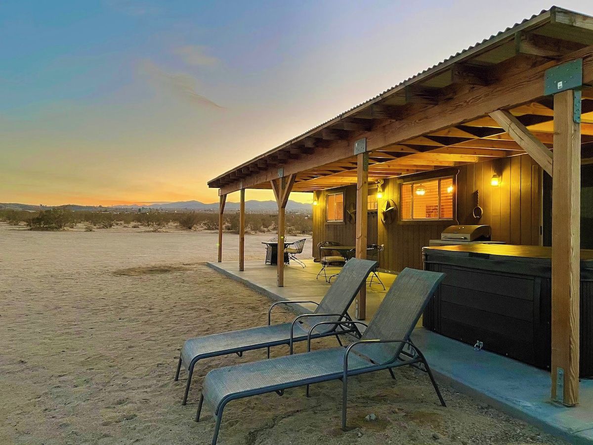 Un chalet situé en bord de mer, doté d’un patio couvert, de chaises longues et d’un jacuzzi.