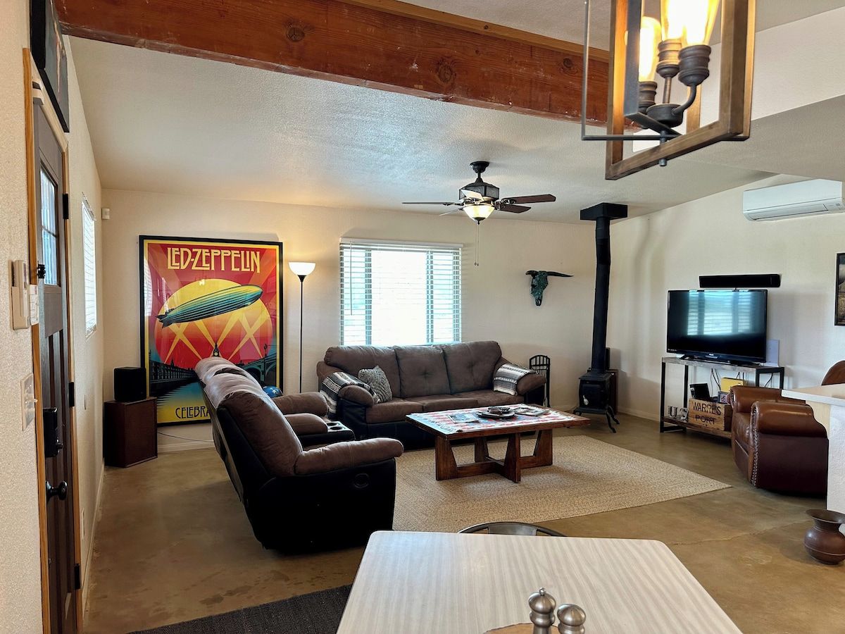 A living room with a sofa, armchair, coffee table, and a television.