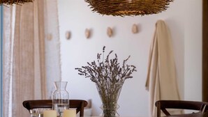 A dining table with a vase of dried flowers, candles, and a glass container.