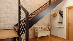 A staircase with a black metal railing, a wooden bench, and a white door with a mirror above it. - Luxury Villa Retreat with Infinity Pool (Labin)