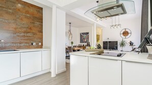 A modern kitchen with white cabinets, a large island, and a unique backsplash. - 2 bedroom accommodation in Alnwick (Alnwick)