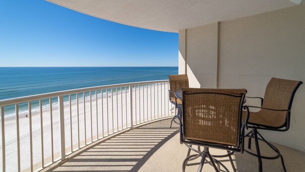A balcony with a view of the ocean, two wicker chairs, and a white railing. - Royal Palms 1002 by Liquid Life (Gulf Shores)