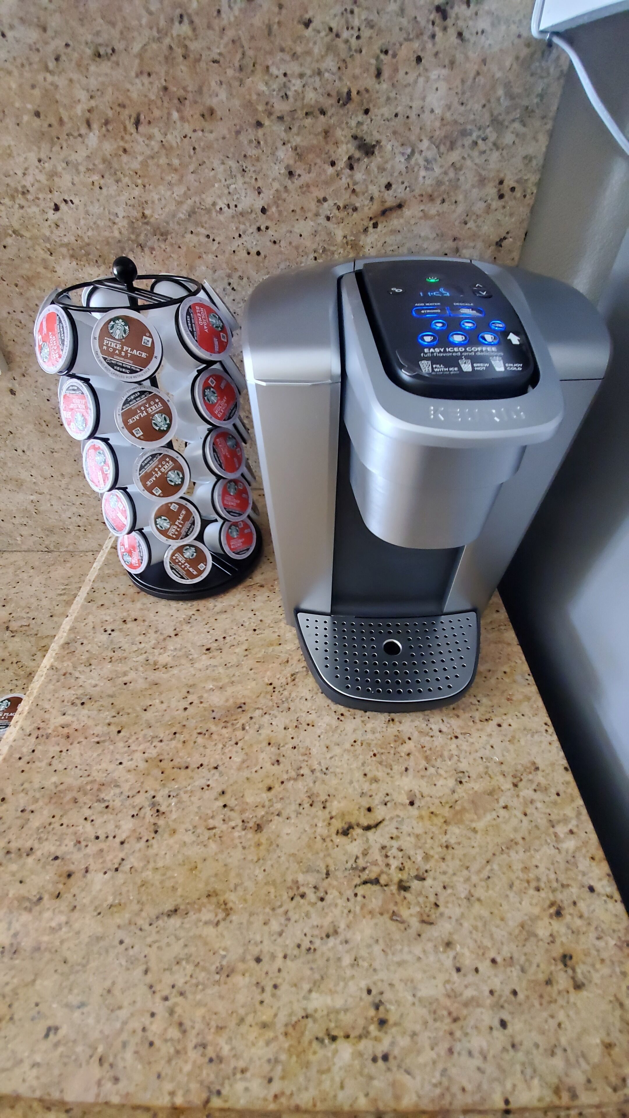 En kaffemaskin med en digital display och ett fack för kaffekapslar som rymmer flera kapslar.