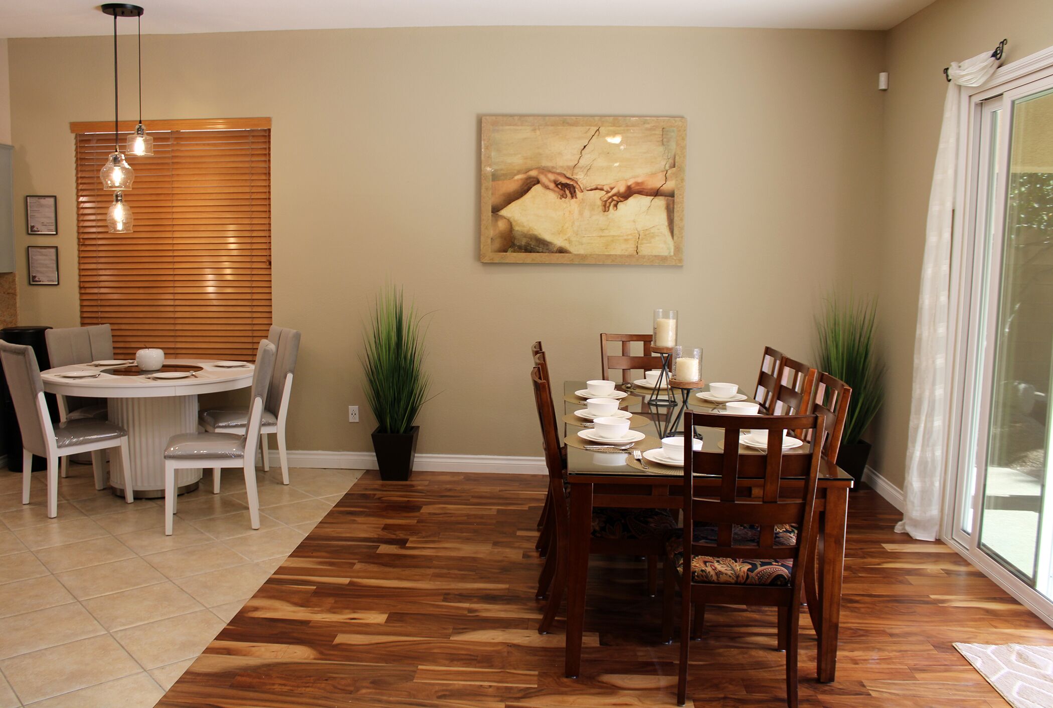 A dining area with a round table set for six, surrounded by wooden chairs.