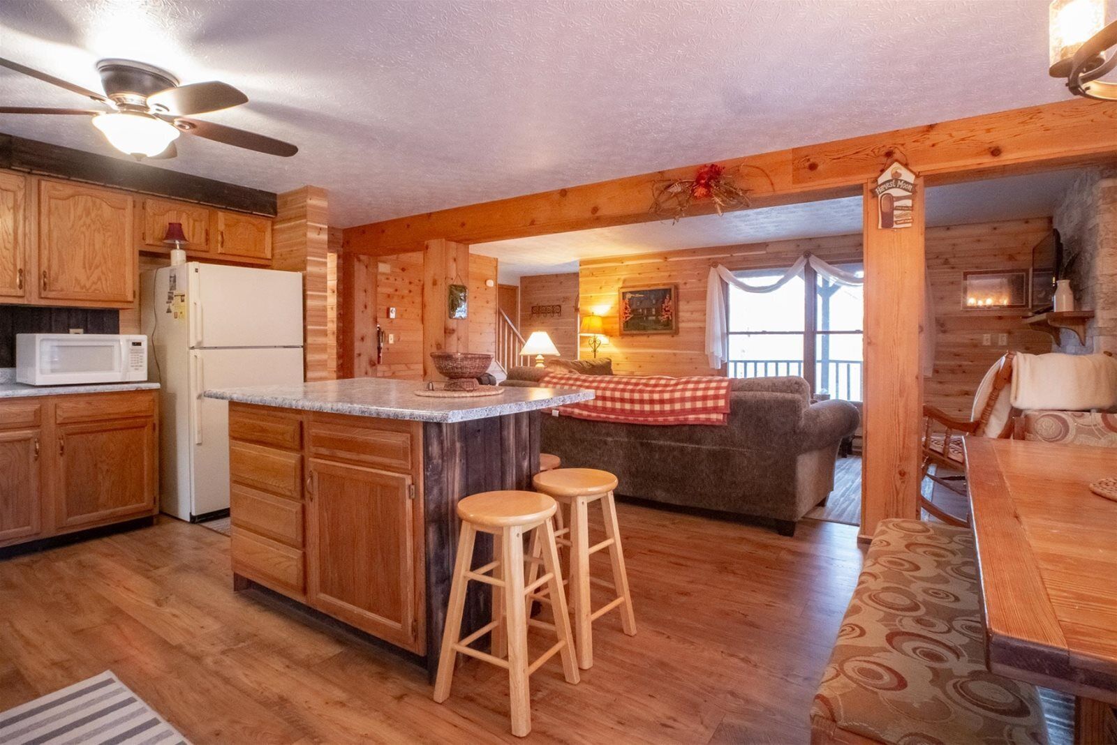 A log cabin interior with a kitchen, dining area, and a cozy living space.