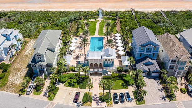 A beachfront property with a large swimming pool, multiple guest houses, and a beach access walkway. - Beach Haven Private Heated Dip Pool! (Palm Coast)