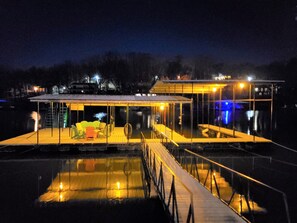 Et hus ved vandet med en overdækket terrasse og en swimmingpool.