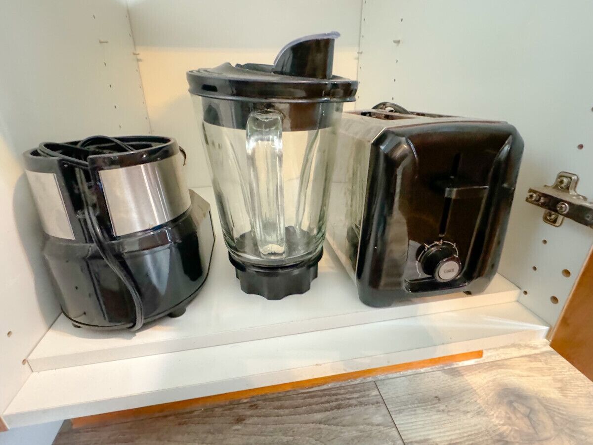 Et køkken med en hvid bordplade og tre apparater: en kaffemaskine, en blender og en brødrister.