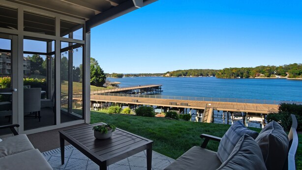 A covered outdoor area with a view of a lake, a wooden deck, and a grassy lawn. - Smith Mountain Lake Condo with Main Channel Views (Moneta)