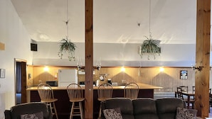 Une cuisine moderne agrémentée d’éléments en bois, avec un coin bar et des sièges pour prendre les repas.