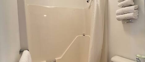 Un baño con bañera, inodoro y un perchero para toallas.