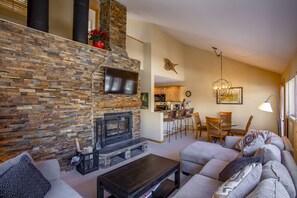 TV connectée, cheminée, livres, chaîne hi-fi