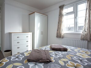 A bedroom with a bed, a wardrobe, and a window with curtains. - 2 bedroom accommodation in Kingsbridge (Kingsbridge)
