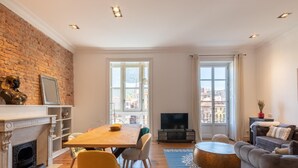 Una sala de estar moderna con chimenea, un comedor y un sofá.