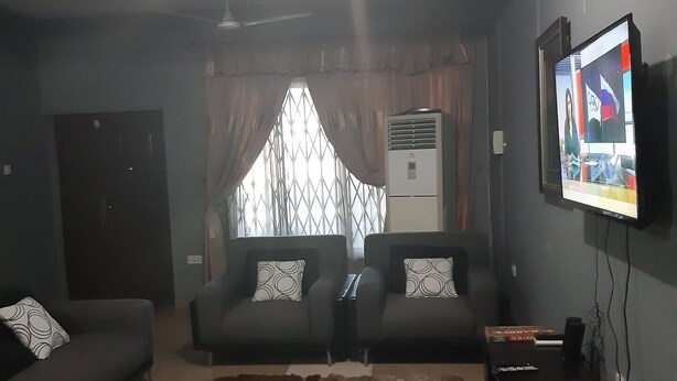 Un soggiorno con due divani, una TV a parete e una ventola a soffitto.