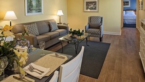 A compact living room with a sofa, armchair, coffee table, and dining area. - Hilton Head vacation resort: 2 blocks from the beach, near restaurants and golf! (Hilton Head Island)