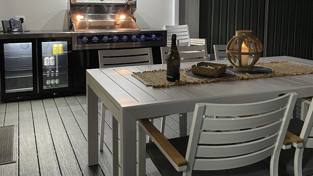 An outdoor patio with a grill, seating, and a table set for dining. - Blue Bay - Close to Fingal Bay Beach. Mid Week Stay Special Now On. (Fingal Bay)