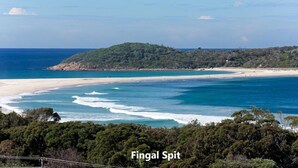 A coastal landscape with a beach, forested hills, and the ocean. - Blue Bay - Close to Fingal Bay Beach. Mid Week Stay Special Now On. (Fingal Bay)