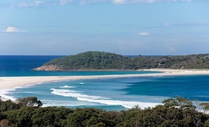 A coastal landscape with a beach, forested hills, and the ocean. - Blue Bay - Close to Fingal Bay Beach. Mid Week Stay Special Now On. (Fingal Bay)