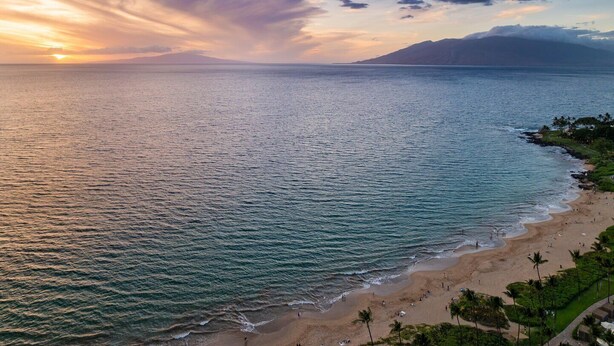 A beach with a view of the ocean and a mountain in the distance. - Ocean View Condo on Sugar Beach Steps to Pool - Nani Kai Hale 308 (Kihei)