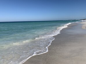 A beach with clear water and a sandy shore. - Cozy beach condo (Bradenton Beach)