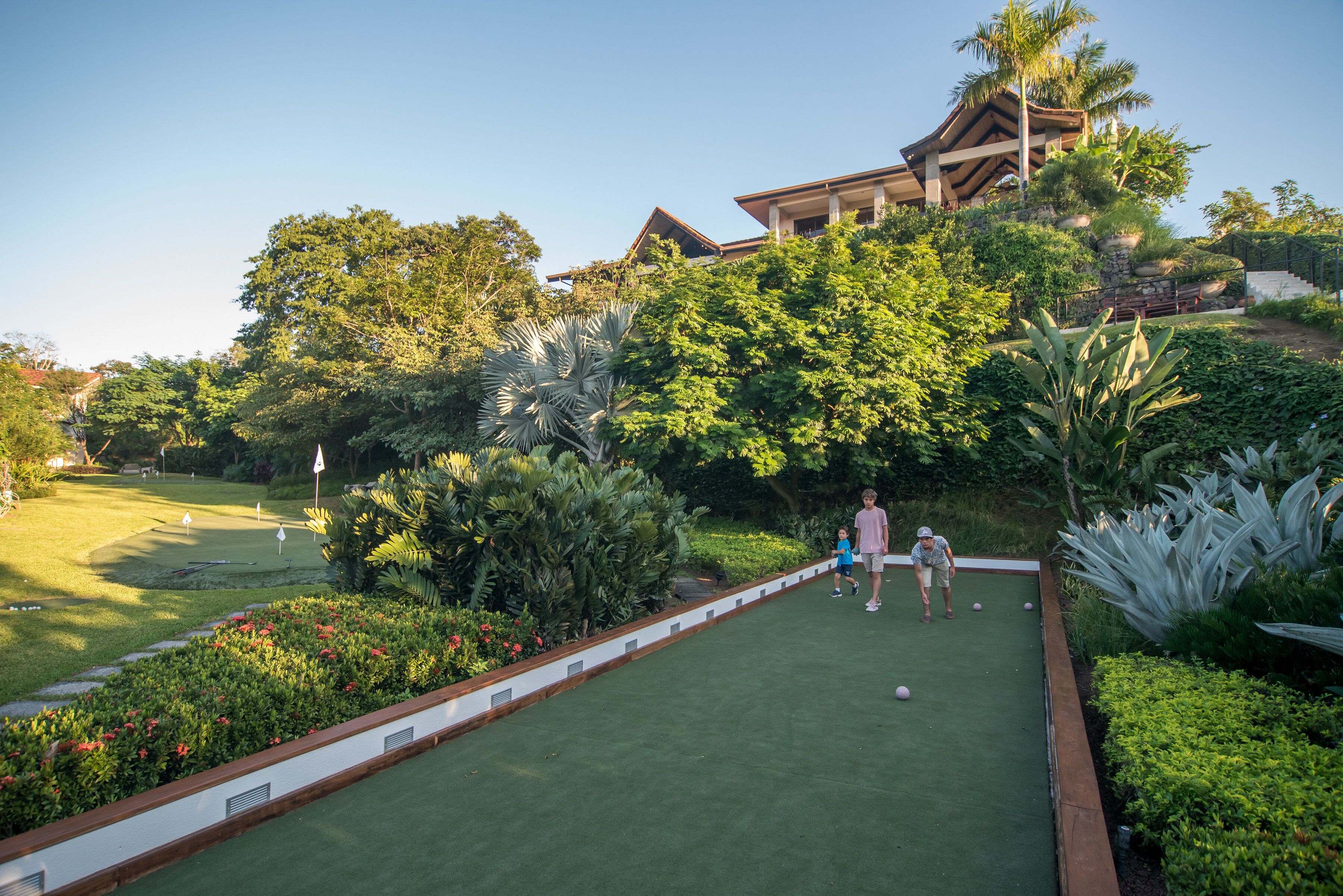 A croquet field with a house in the background.