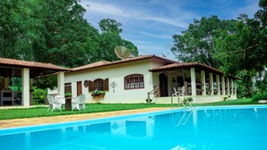 Ein Haus mit Swimmingpool, Satellitenschüssel und Gartenmöbeln.